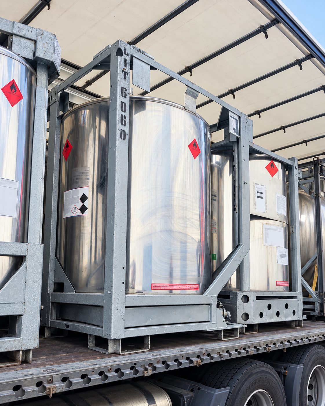 Nerūdijančio plieno IBC talpyklos su pavojingųjų krovinių ženklais, pritvirtintos puspriekabėje