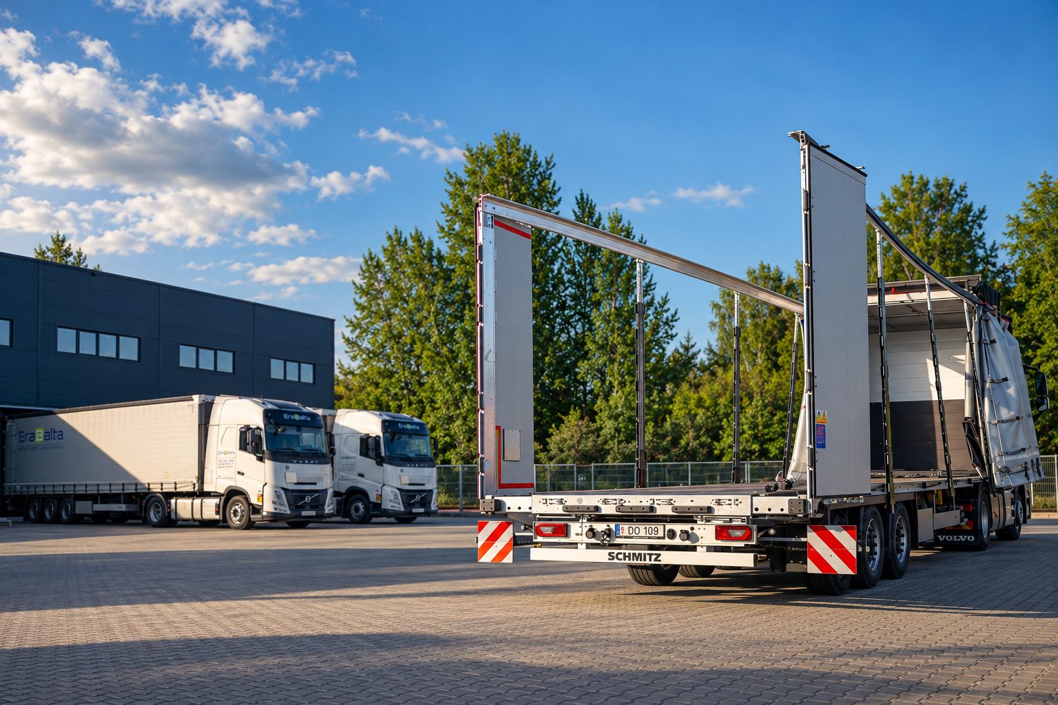 Widened Mega trailer with the roof raised and the curtains pulled back at a terminal, Erabalta trucks in the background