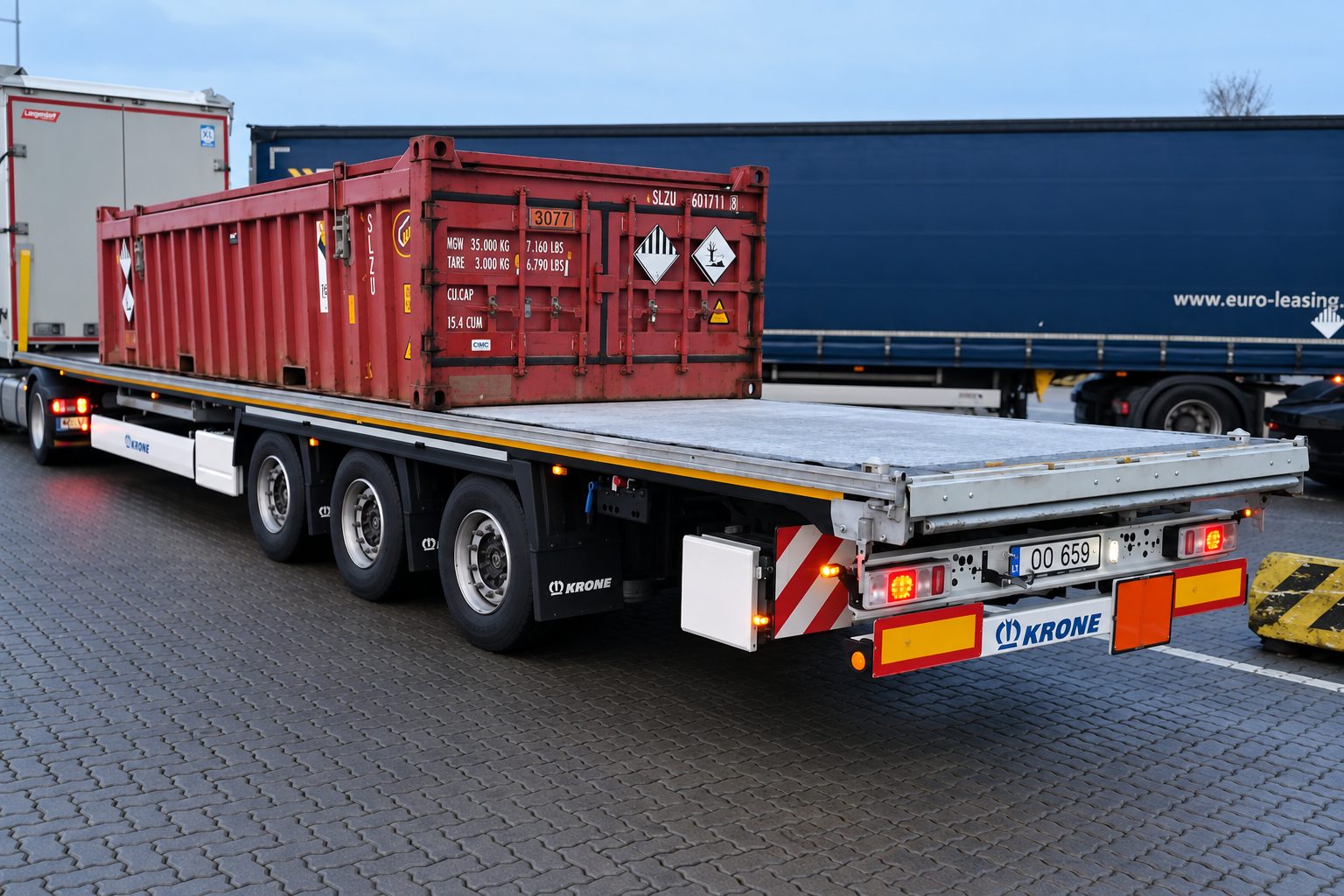 Red container with dangerous goods placards on a flatbed semi-trailer