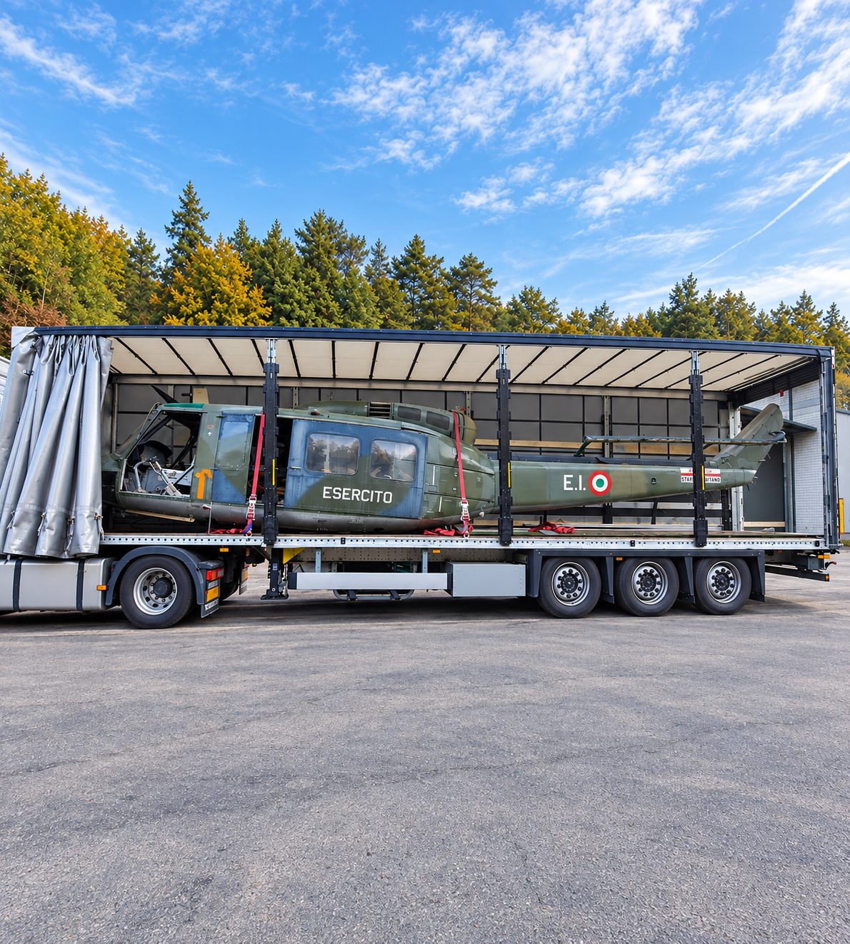 Helicopter secured on a semi-trailer with the curtains open