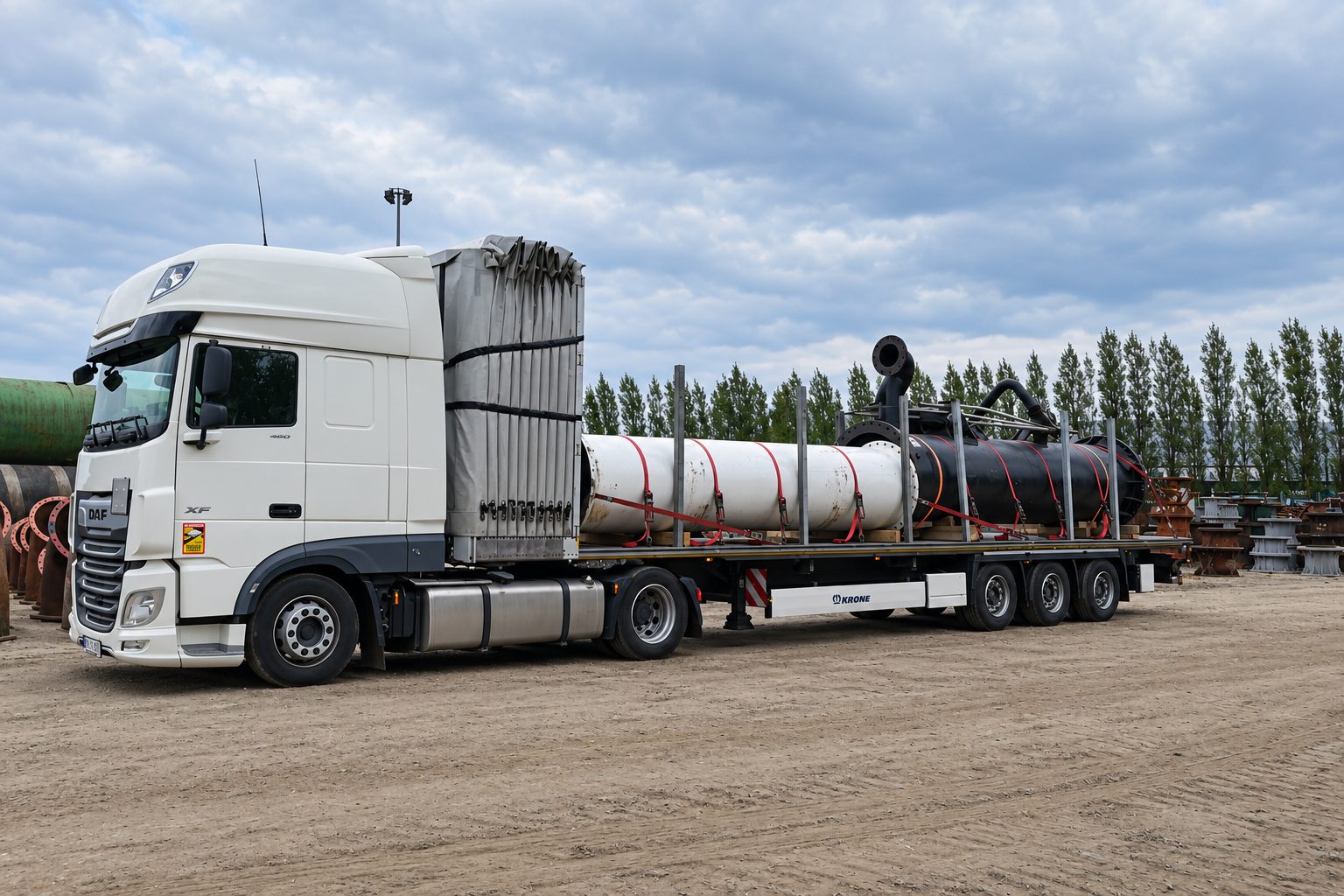 Truck with pipes secured between stanchions on a flatbed