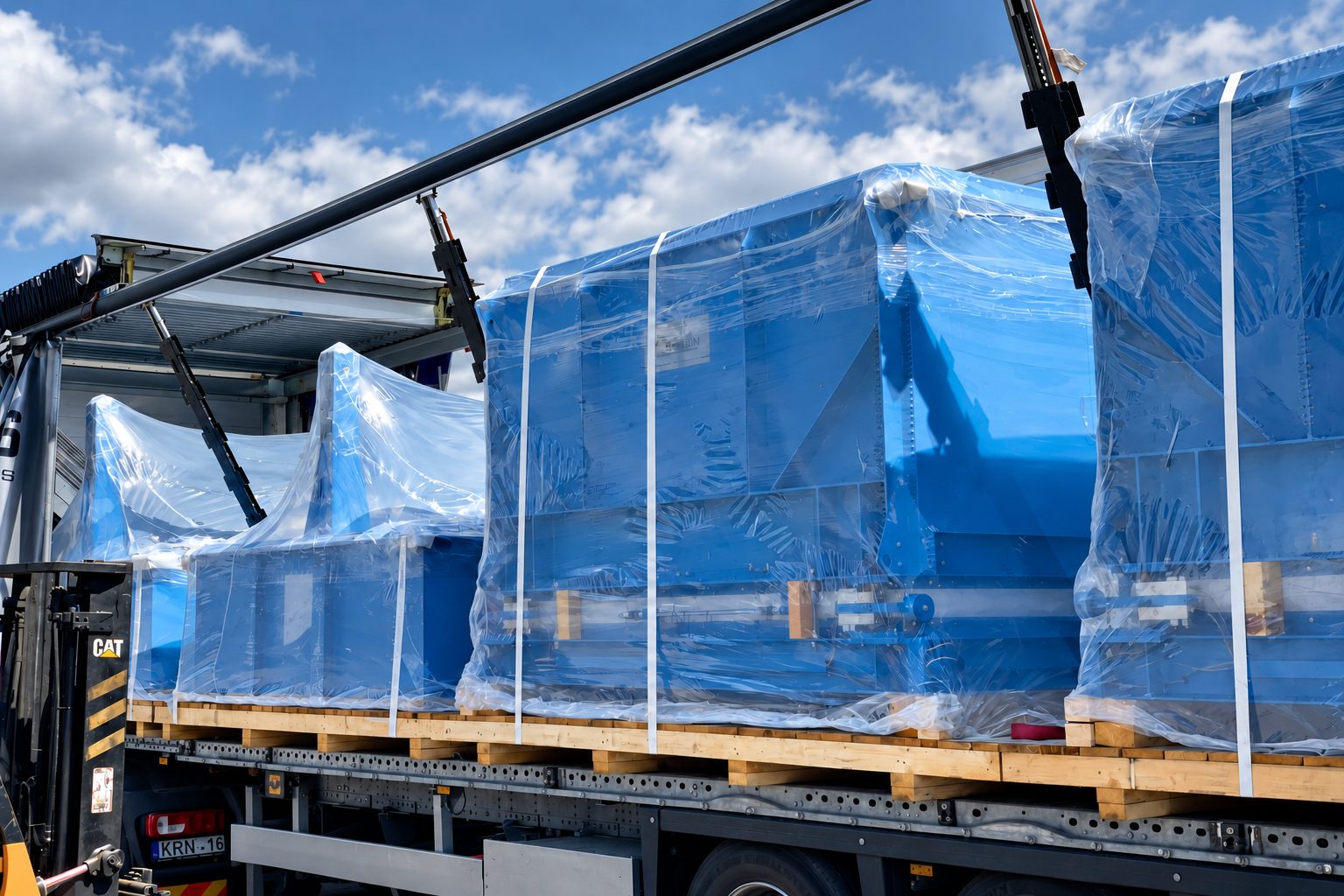 Freight transport: blue industrial tanks wrapped in film being loaded into a Mega trailer